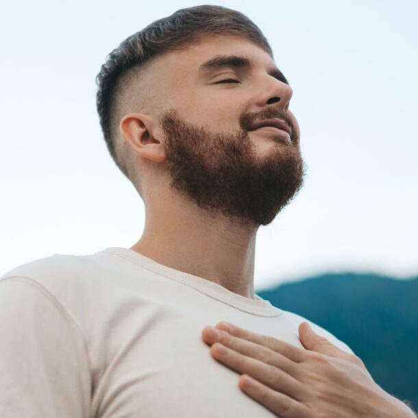 Man putting hand over his chest and practicing mindfulness with his eyes closed